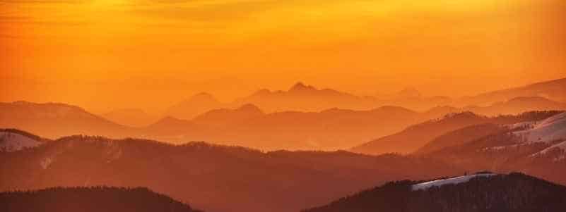 Orange sunset over rolling hills