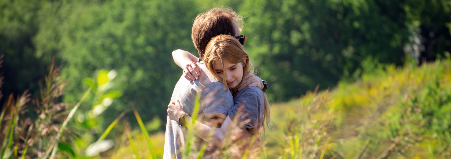 A woman and a man hug in nature
