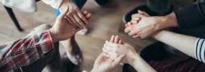 Photo focuses on a group of people holding hands