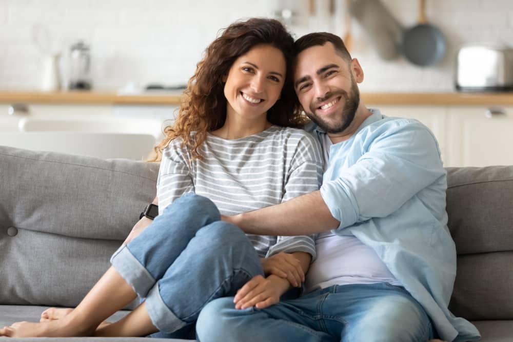 A woman and man cuddling on the couch